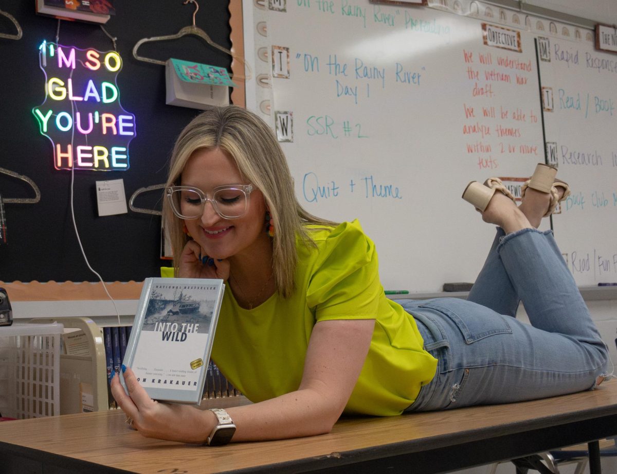 Lying on a desk in her classroom, Mrs. Christina Lentz poses with her favorite book on April 15. After graduating from Francis Howell Central herself, Mrs. Lentz later became a teacher and has won teacher of the year in a previous year.