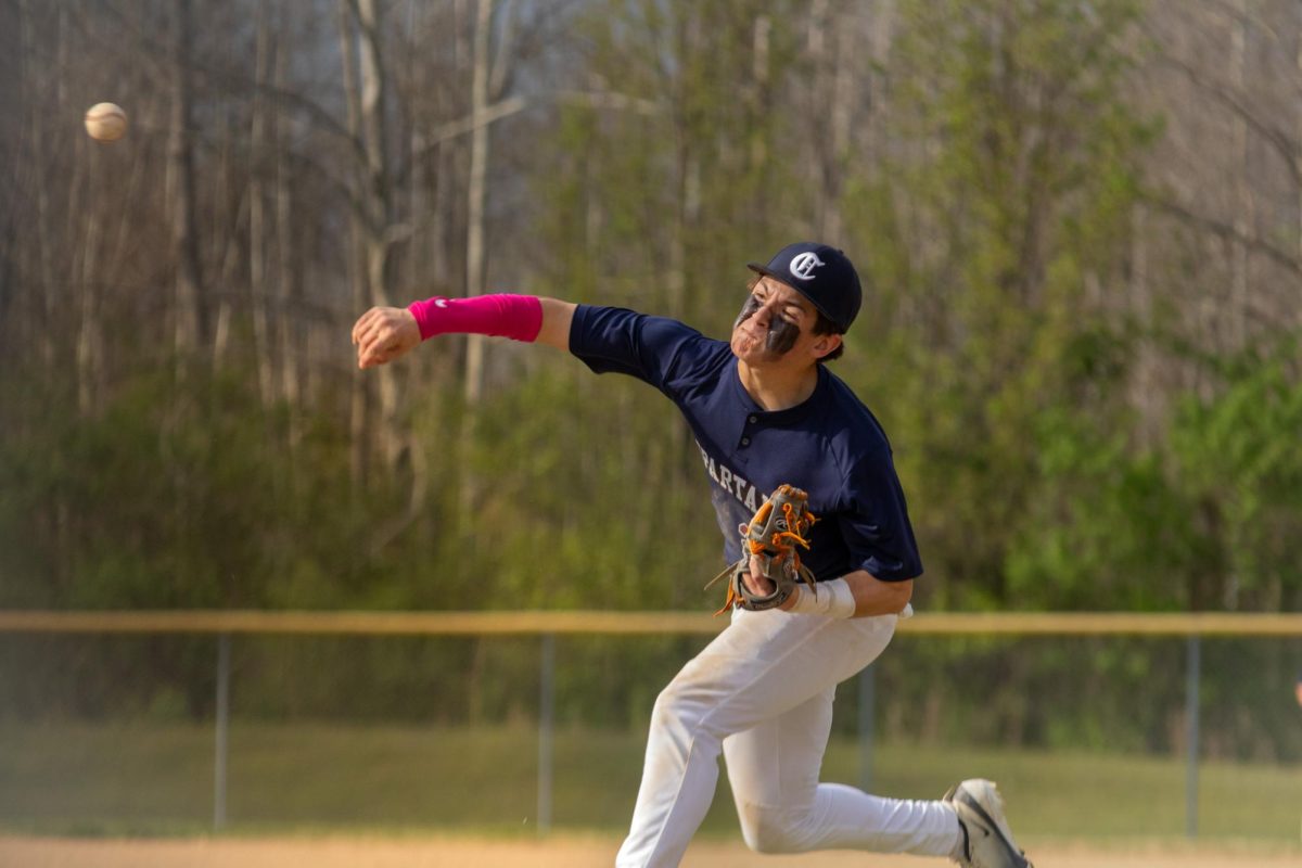 With a look of pure determination, Seth Nichols hurls a pitch through the air toward the batter on March 31. He followed through with an arm motion across his body and a large step toward the base of the pitching mound. 