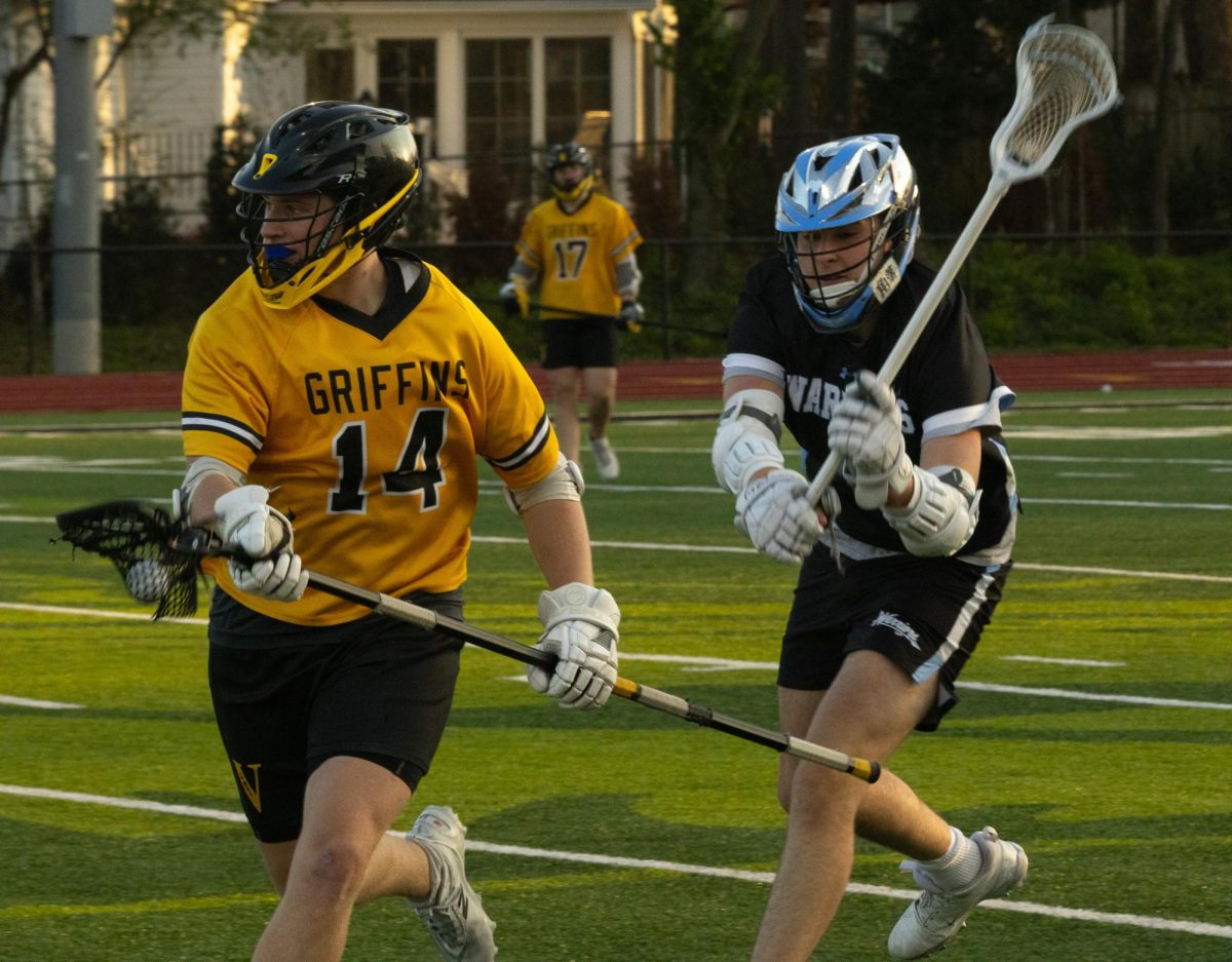Swinging his stick down for the check at the game on April 7th, junior Jack Ney helps to try and get the ball back from the other team. Ney checked the opponents stick to try to get him to drop the ball.