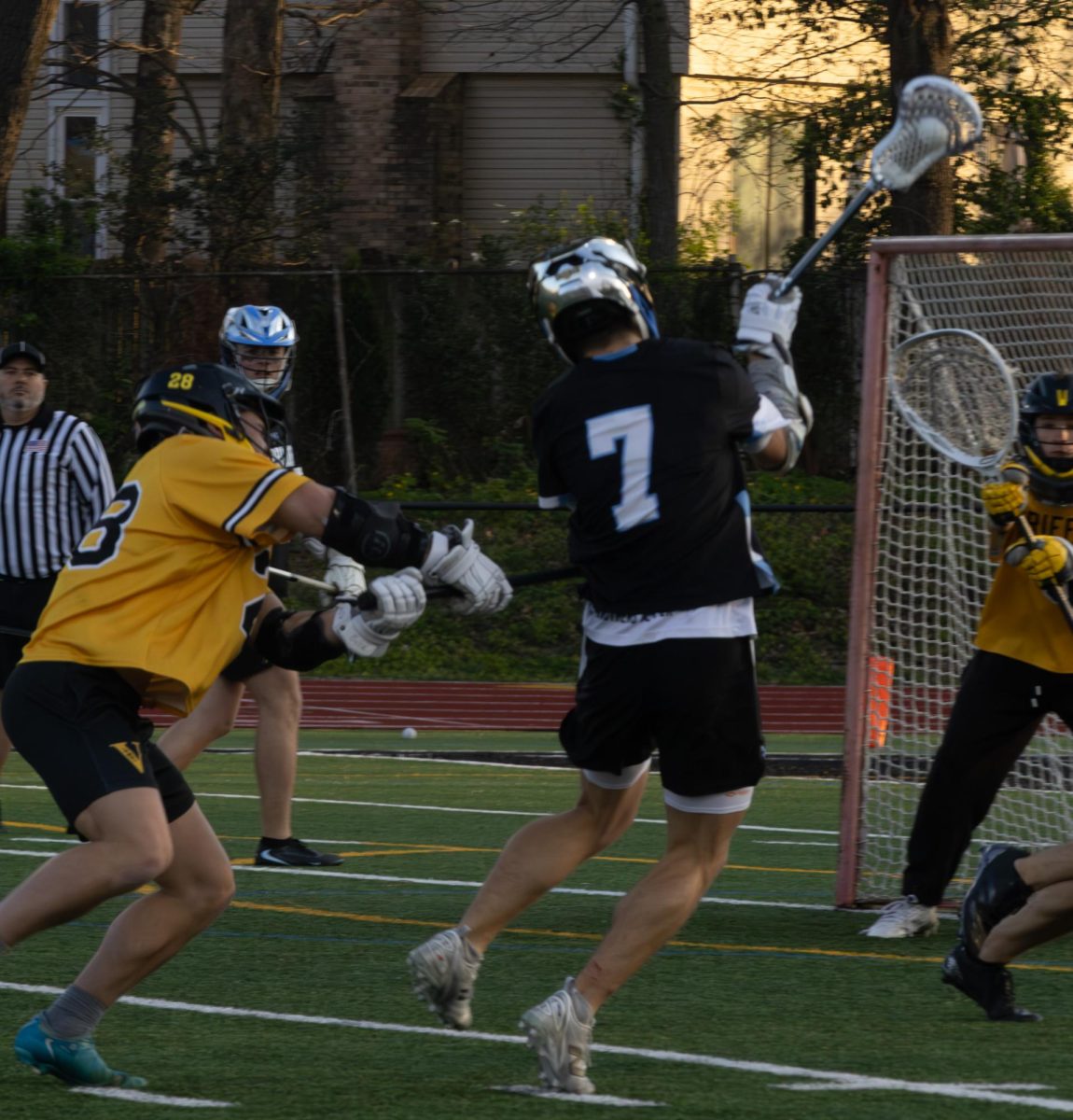 Leaping into the air, senior Brady Dethloff jumps up over the opposite team to get a good line of sight to try and score at the game on April 7th. Dethloff had to make sure there weren't too many people around so he could get a good shot.