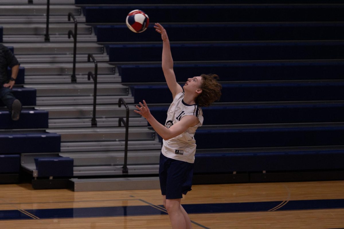 Sophomore Owen Barbeau serves the ball to the opposing side during the game on April 23. Serves focus more of placement than power, making it a technical maneuver.