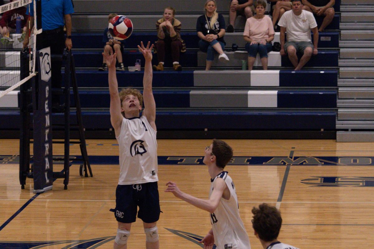 Junior Colton Jones sets the ball for his teammate to smash during the game on April 23. Setting a ball takes control and precision, getting the ball in the perfect place for a teammate to smash.