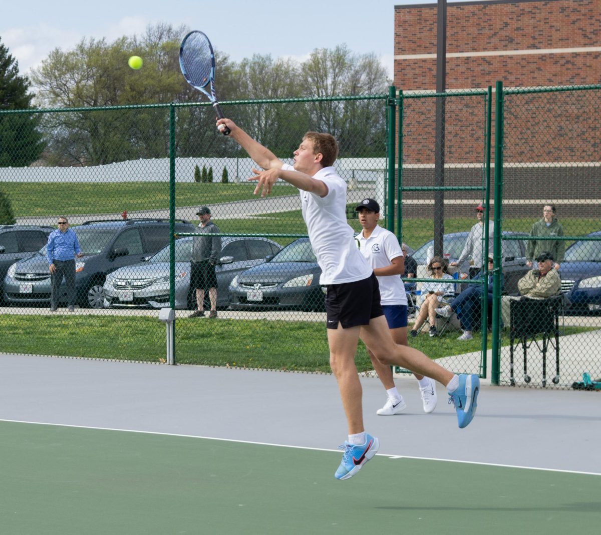 Freshman Tejas Marathe moves behind the baseline as junior Luke Wiehage jumps to reach a lobbed ball from their opponents from North. After hitting the ball, Marathe runs back to the net and finishes the point with a strong volley on April 2.
