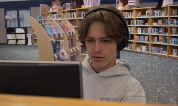 Junior Hayden Roumpos studies while listening to music in the library. Music is one way many students keep their study time relaxed.