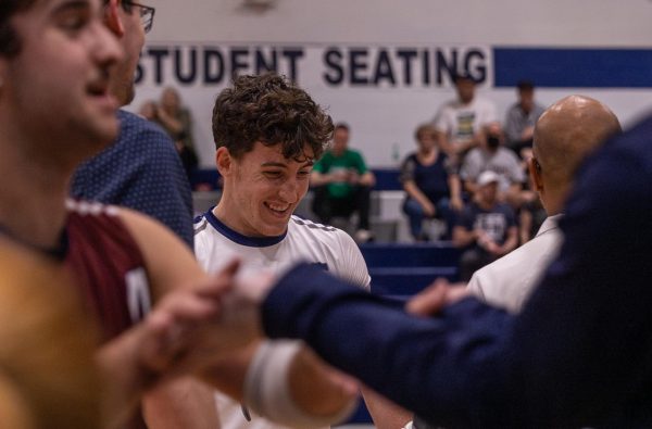 After another point is scored by the Spartans, senior Jason Campbell smiles as his coach while other Spartan players high five each other. As an outside hitter, Campbell delivered many point scoring spikes throughout the game on April 23.
