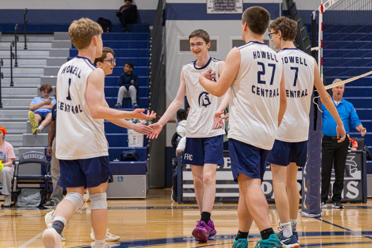 After contributing a valuable point, sophomore Galen Davis high-fives his teammates as they congratulate him for the ball he had just slammed down. Davis was set to for most of the rallies, giving the other team no chance against his height and strength of his swing.