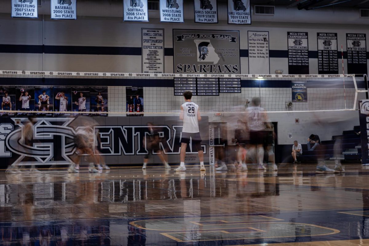 Standing on the court, on April 23, Caleb Dolan is in position during the start of a rally. Dolan is six feet seven inches tall, which is a great advantage, allowing him to reach higher and block more balls.
