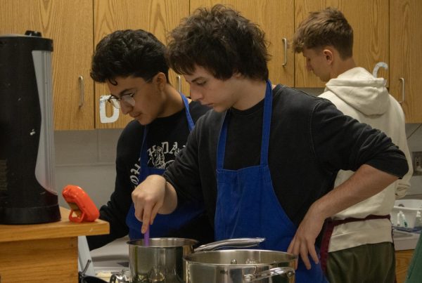 Their timer runs down for their pasta as junior Isaac McDonnell group checks the recipe for fettuccine alfredo. They ensure they have added all of the ingredients before they begin to find the right thickness of the sauce on Jan. 8.