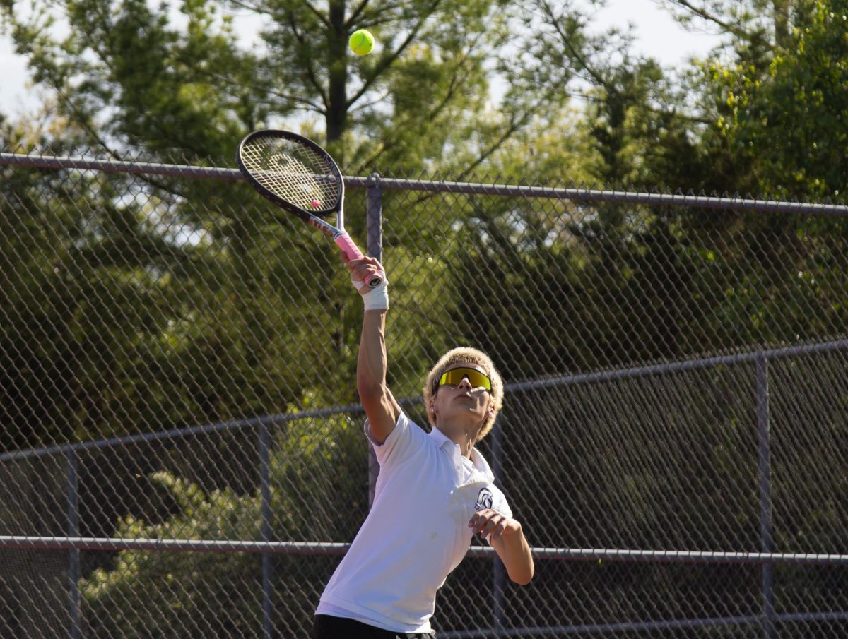 Sophomore Nick Hopkins serves the ball during a match on April 16. Hopkins served, then the opposing team received it.